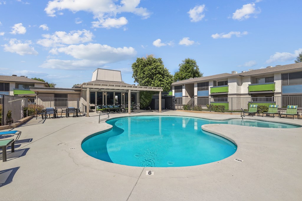 our apartments have a large swimming pool and a patio with chairs